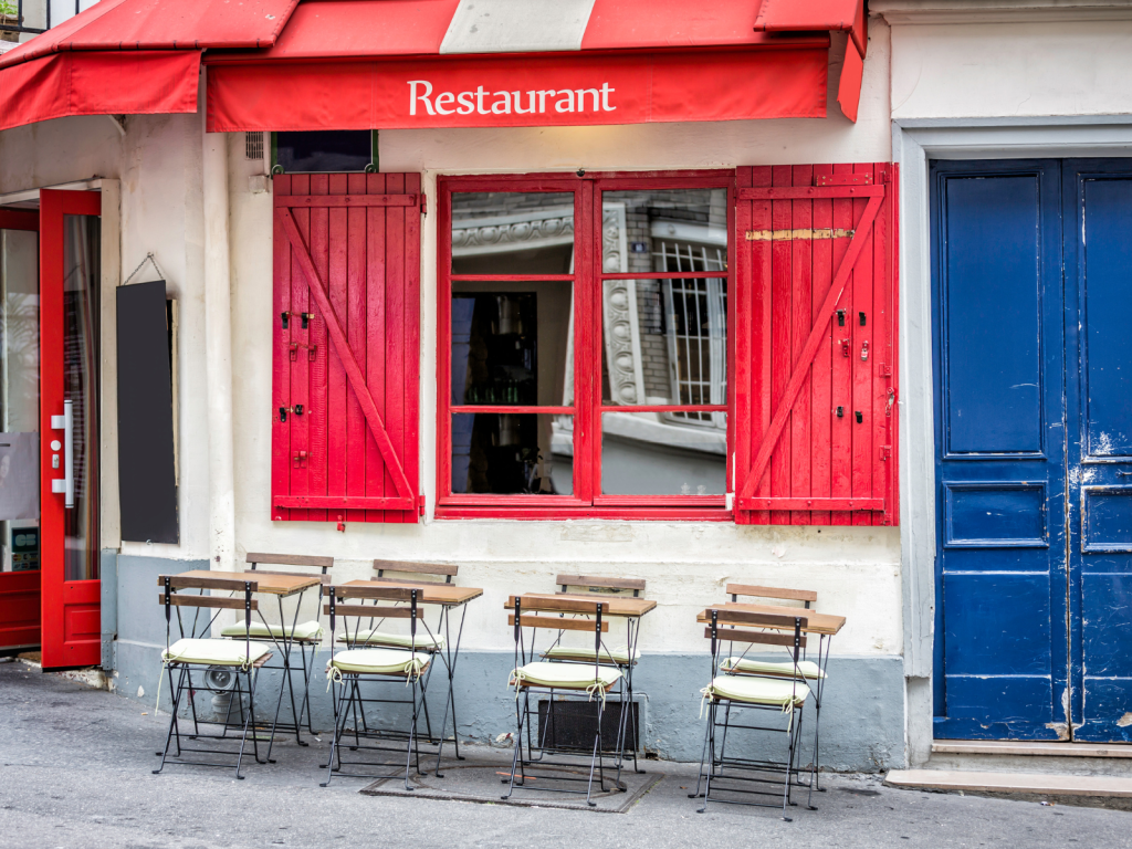 Budynek restauracji z czerwonymi okiennicami i niebieskimi drzwiami