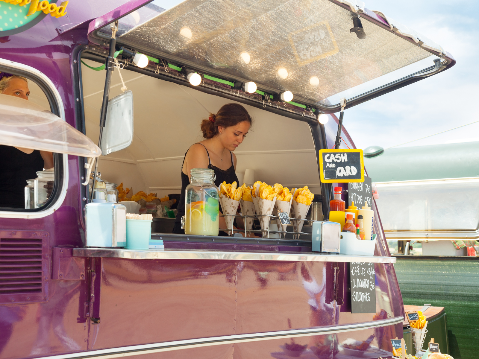 Kobieta pracująca w food trucku z jedzeniem.