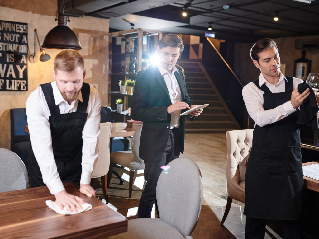 Menedżer w restauracji kontrolujący pracę kelnerów 