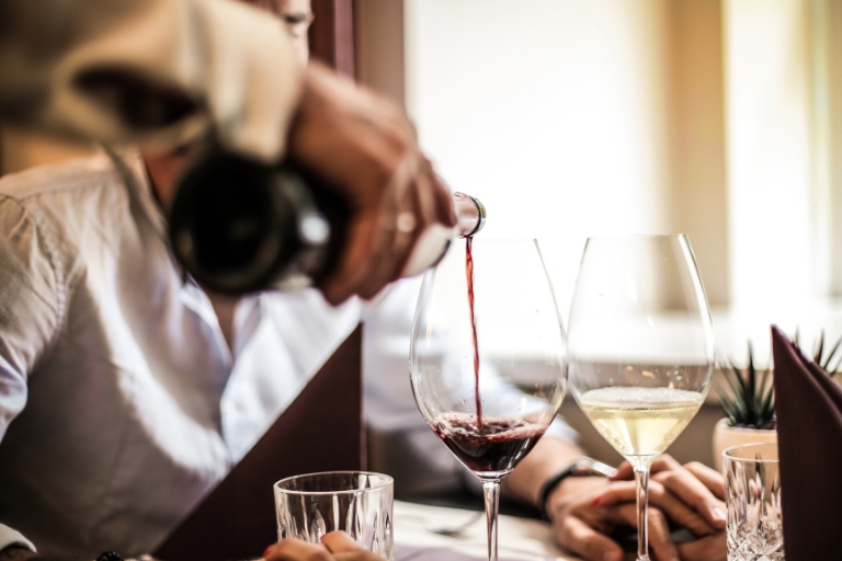 Kelner w restauracji fine dining serwuje wino.